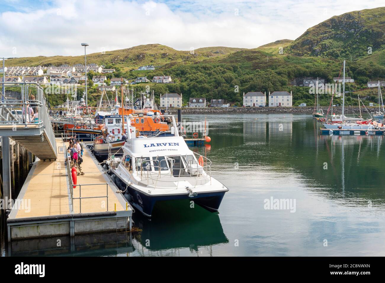 MALLAIG HARBOUR LOCHABER COSTA OCCIDENTALE SCOZIA CON BARCHE CHE INCLUDONO UN BAGNINO E PASSEGGERI PER IL TRAGHETTO LARVEN KNOYDART E LE ISOLE OCCIDENTALI Foto Stock