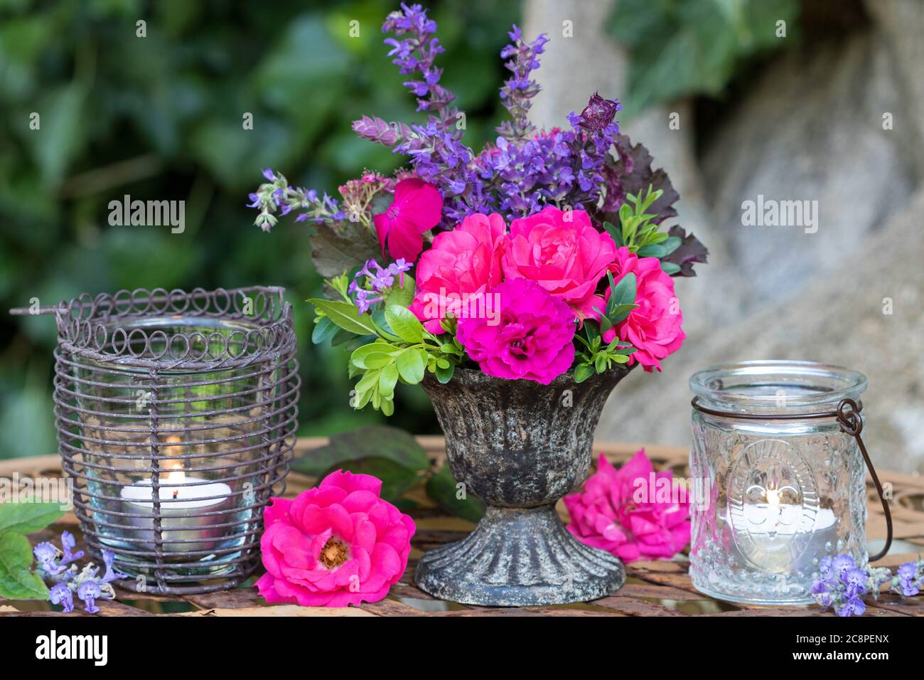 decorazione estiva d'epoca con bouquet di rose rosa e tavolo lanterne Foto Stock