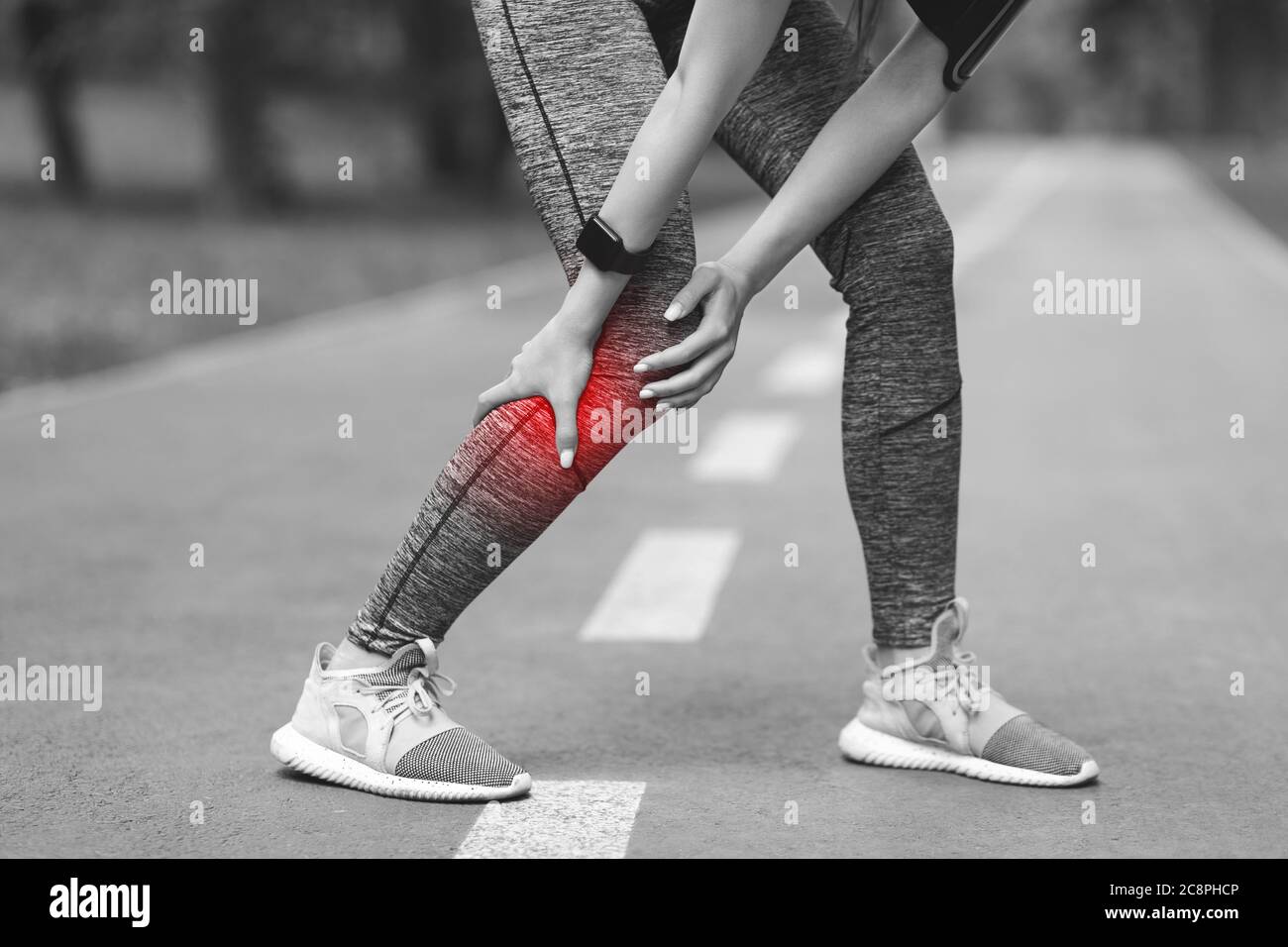 Trauma sportivo. Femmina jogger con vitello ferito massaggiando doloroso muscolo gamba all'aperto Foto Stock