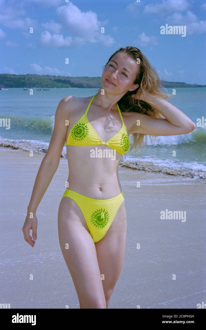 sorridente bella femmina con capelli lunghi indossando bikini in piedi sulla spiaggia di kuta bali indonesia 2002 Foto Stock