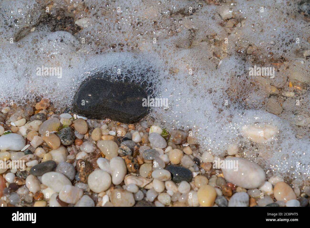 Marmo bagnato e graniti sulla spiaggia dell'oceano Foto Stock