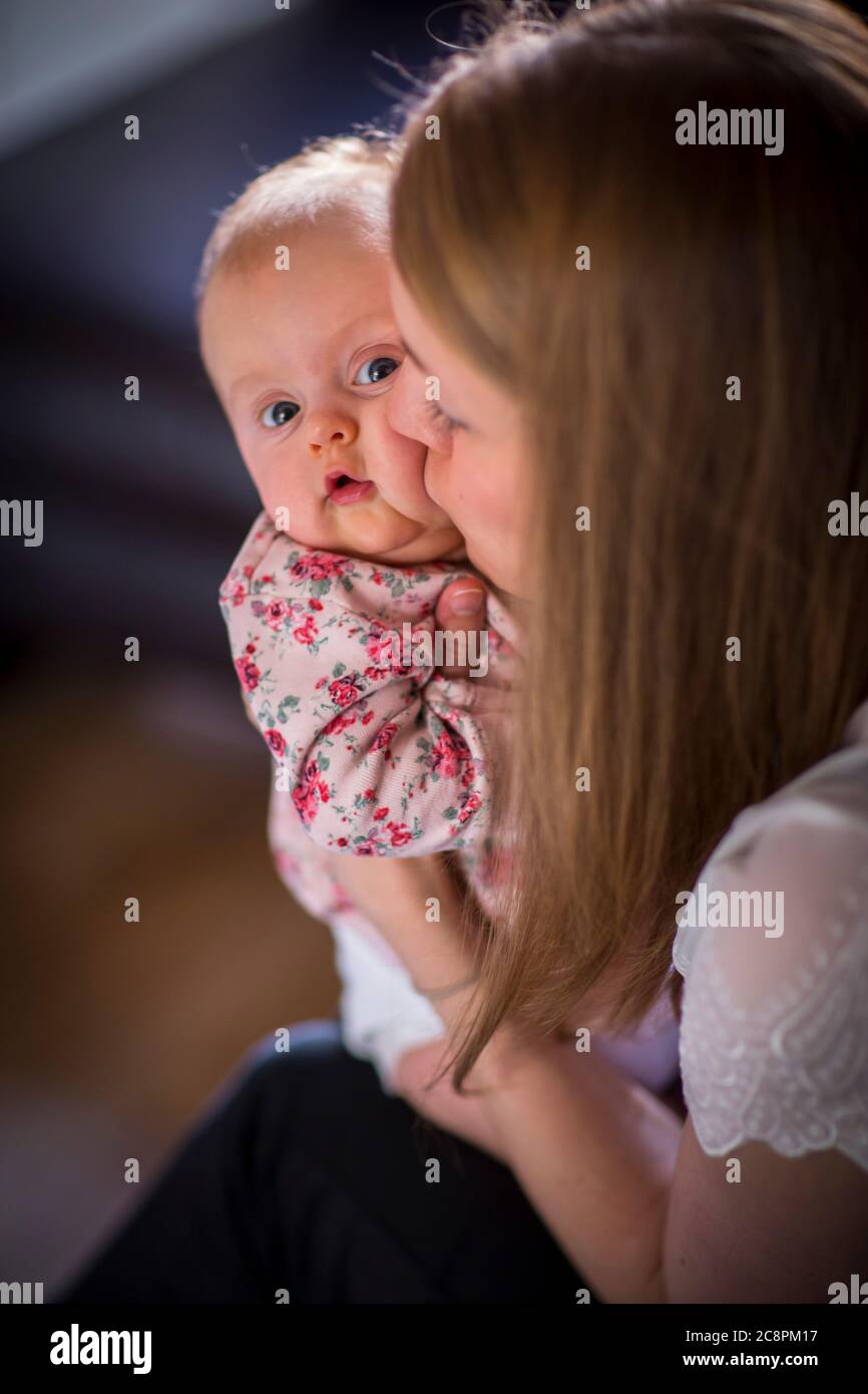Donna che bacia un bambino giovane sulla guancia Foto Stock