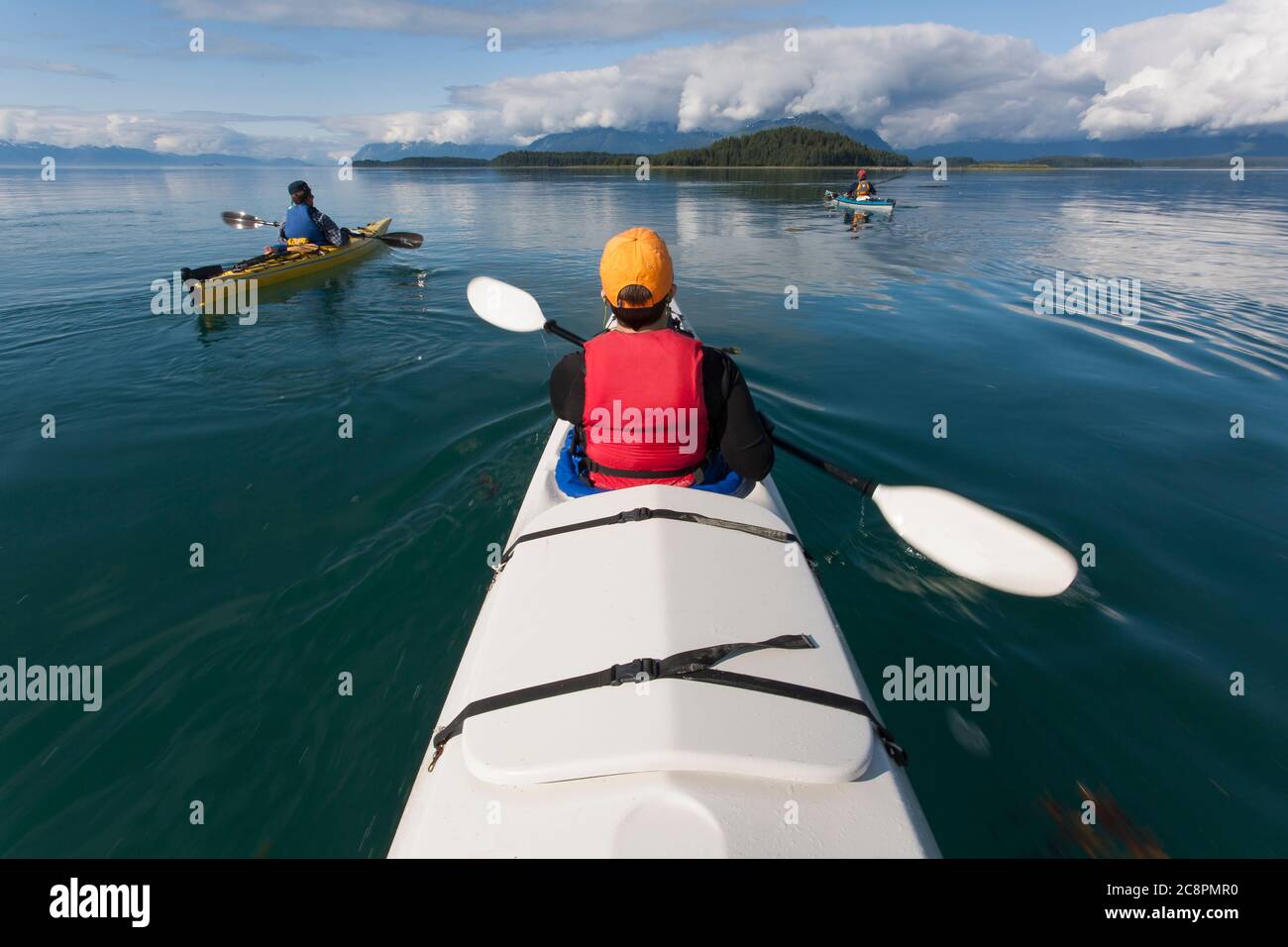 Un piccolo gruppo di persone kayak in acque incontaminate di un'insenatura sulla costa dell'Alaska. Foto Stock