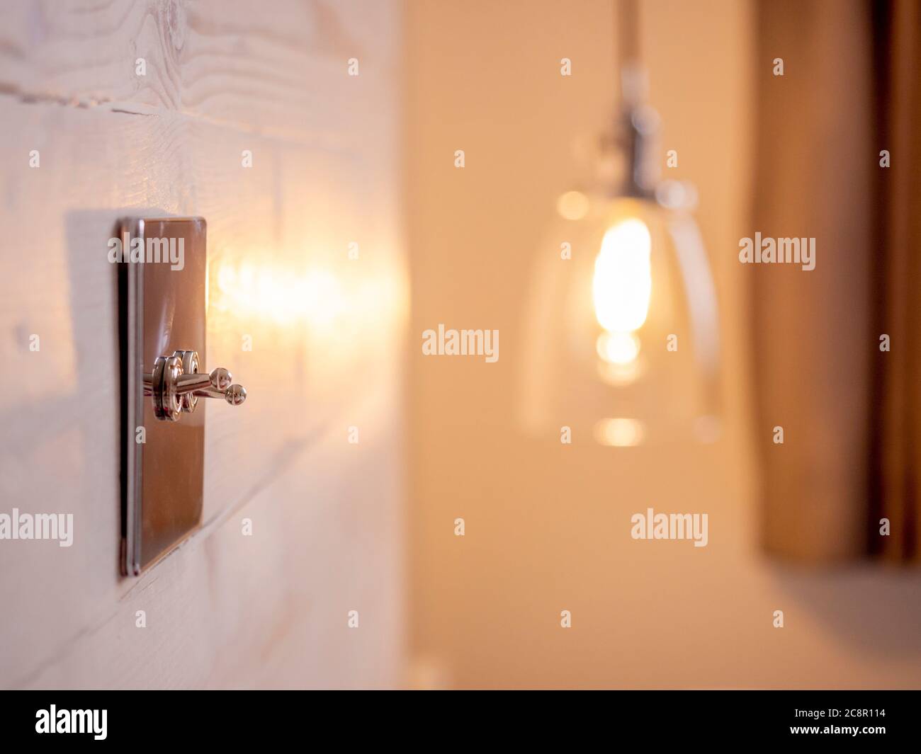 Interruttori a levetta cromati in stile retrò montati sulla testiera in legno della camera da letto. Foto Stock