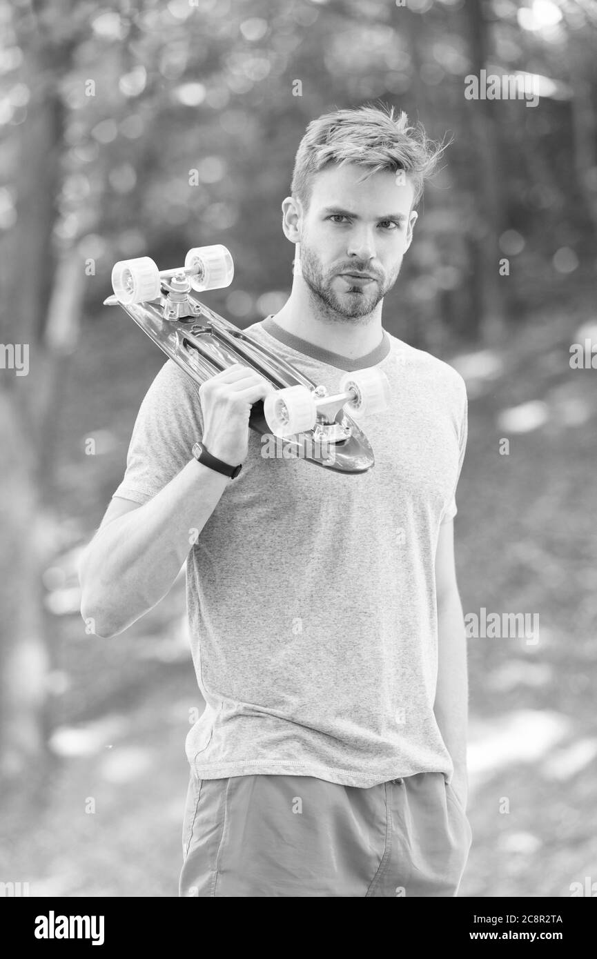Penny Board è il suo compagno di viaggio. Bel ragazzo tenere penny bordo all'aperto. Atletica skater con tavola rosa. Velocità e bilanciamento. Attività ricreative. Sport d'azione. Equitazione in grande stile a bordo. Foto Stock