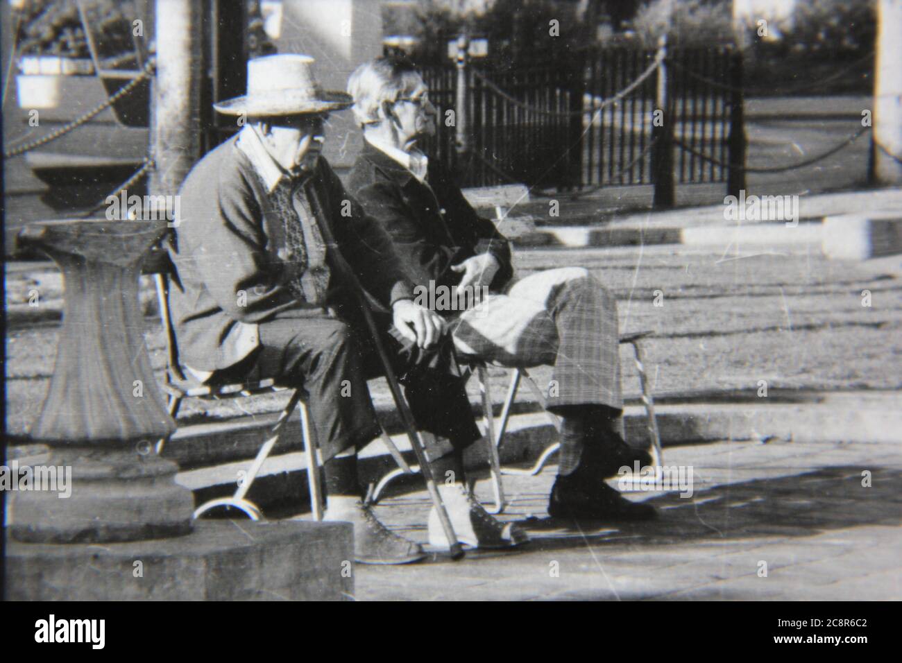 Bella fotografia in bianco e nero degli anni '70 di due vecchi amici che trascorrono il pomeriggio al parco pubblico locale. Foto Stock