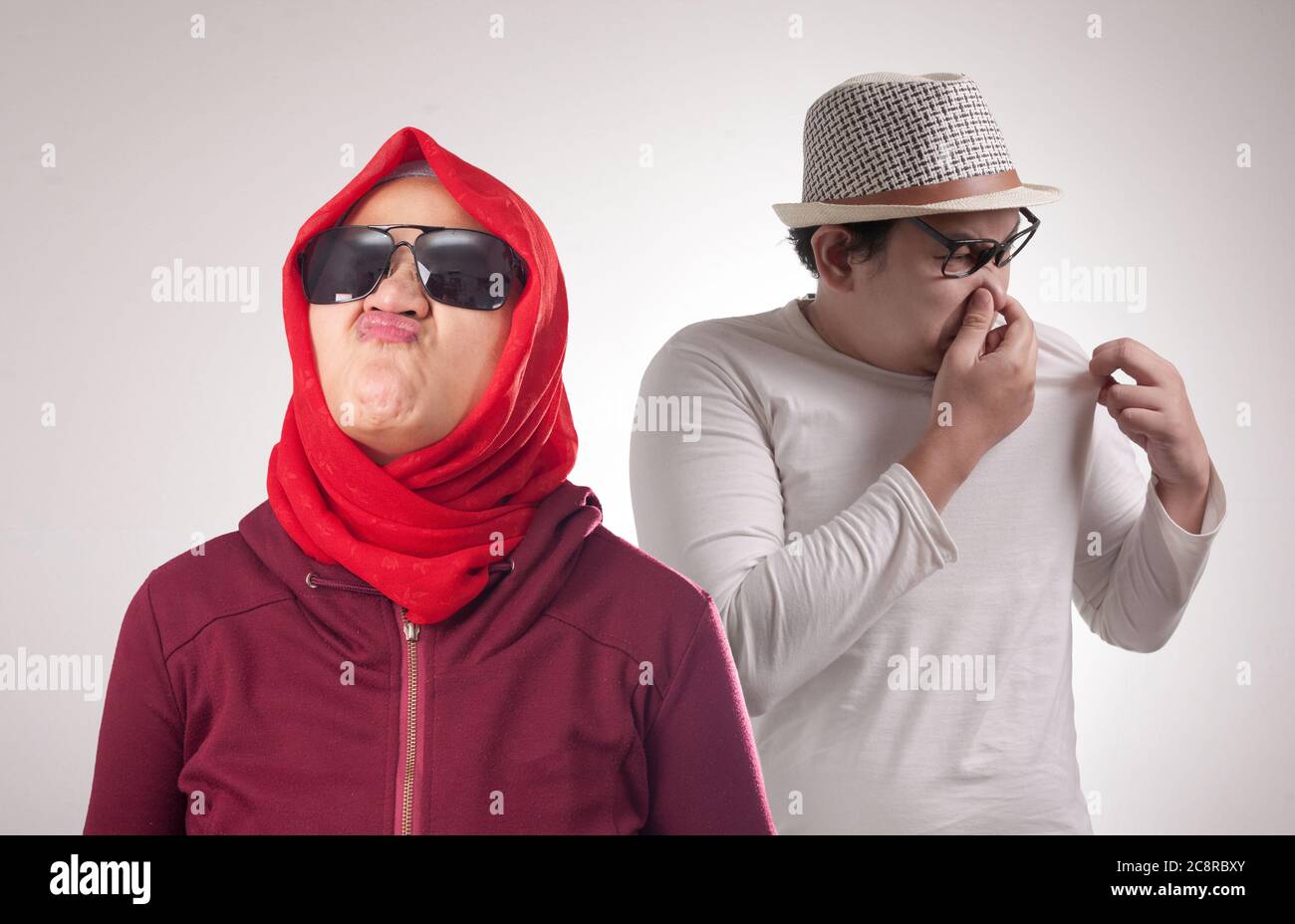 Divertente uomo asiatico imbarazzato di fronte alla donna di avere cattivo odore del corpo, l'uomo odorare il proprio corpo Foto Stock