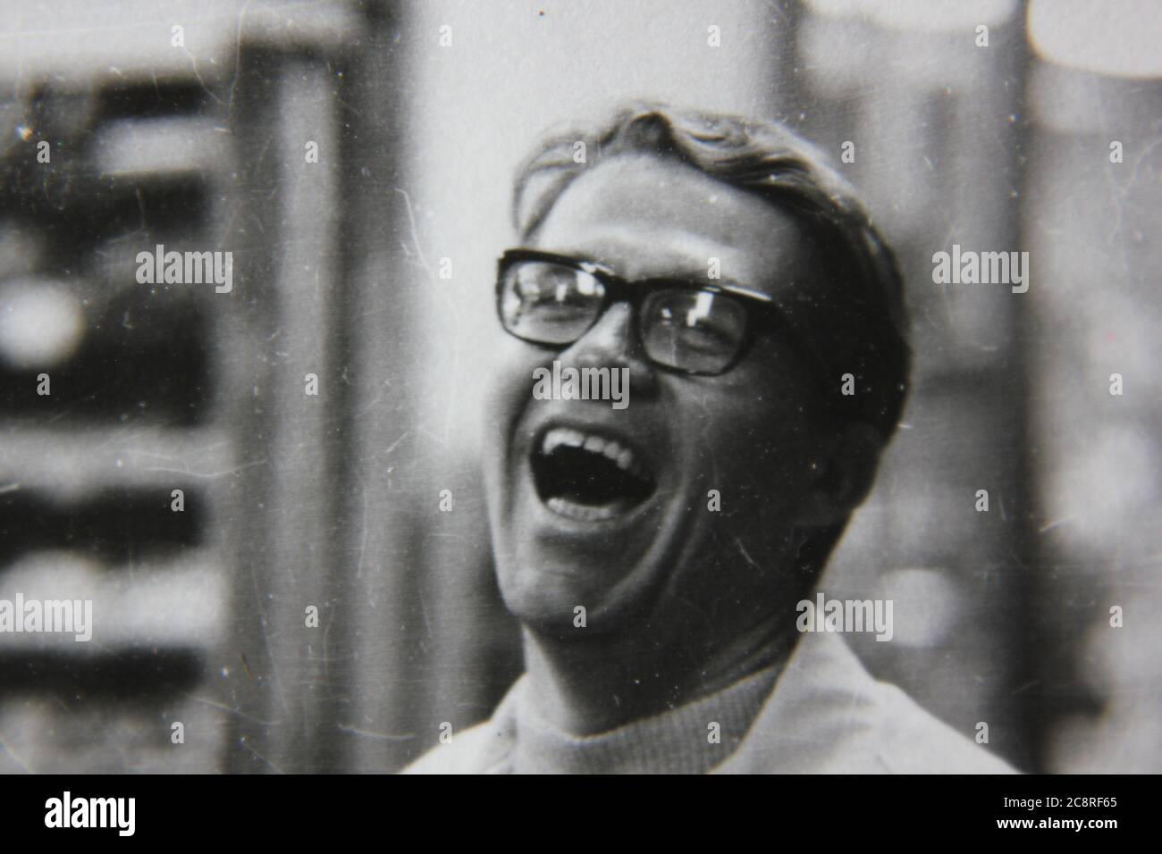 Fine anni '70 vintage stile di vita in bianco e nero fotografia di un uomo che ride profondamente mentre si guarda la fotocamera. Foto Stock
