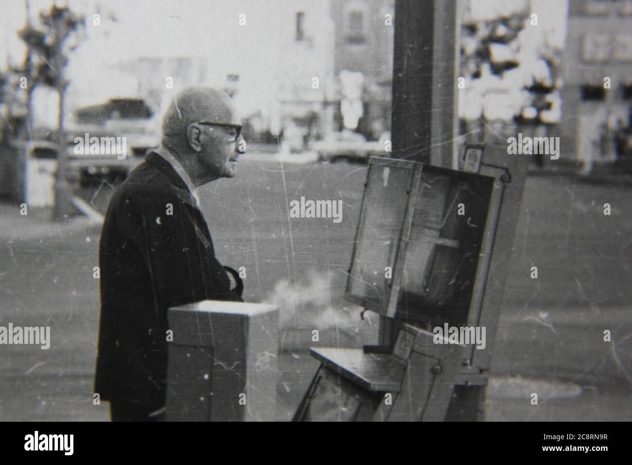 Fine anni '70 vintage nero e bianco stile di vita fotografia di un uomo anziano fuori per la sua passeggiata mattutina acquistare un giornale dalla locale edicola. Foto Stock