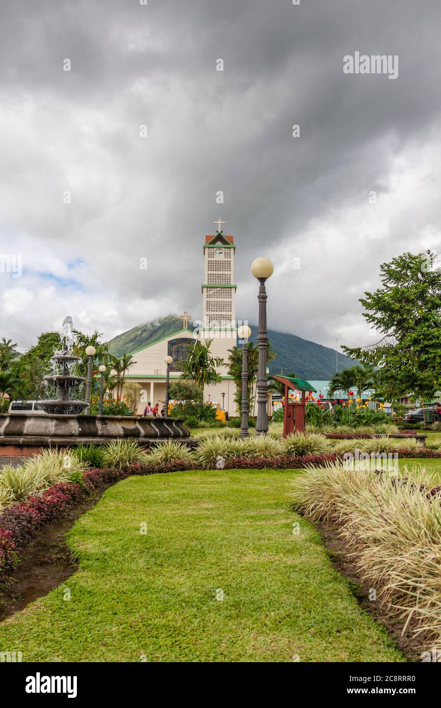 Chiesa cattolica a la Fortuna, Costa Rica, con il vulcano Arenal sullo sfondo. Arenal è un vulcano attivo. Foto Stock