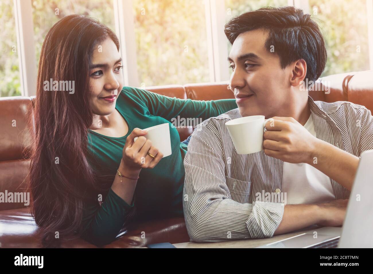 Happy Asian coppia bere caffè a casa. Foto Stock
