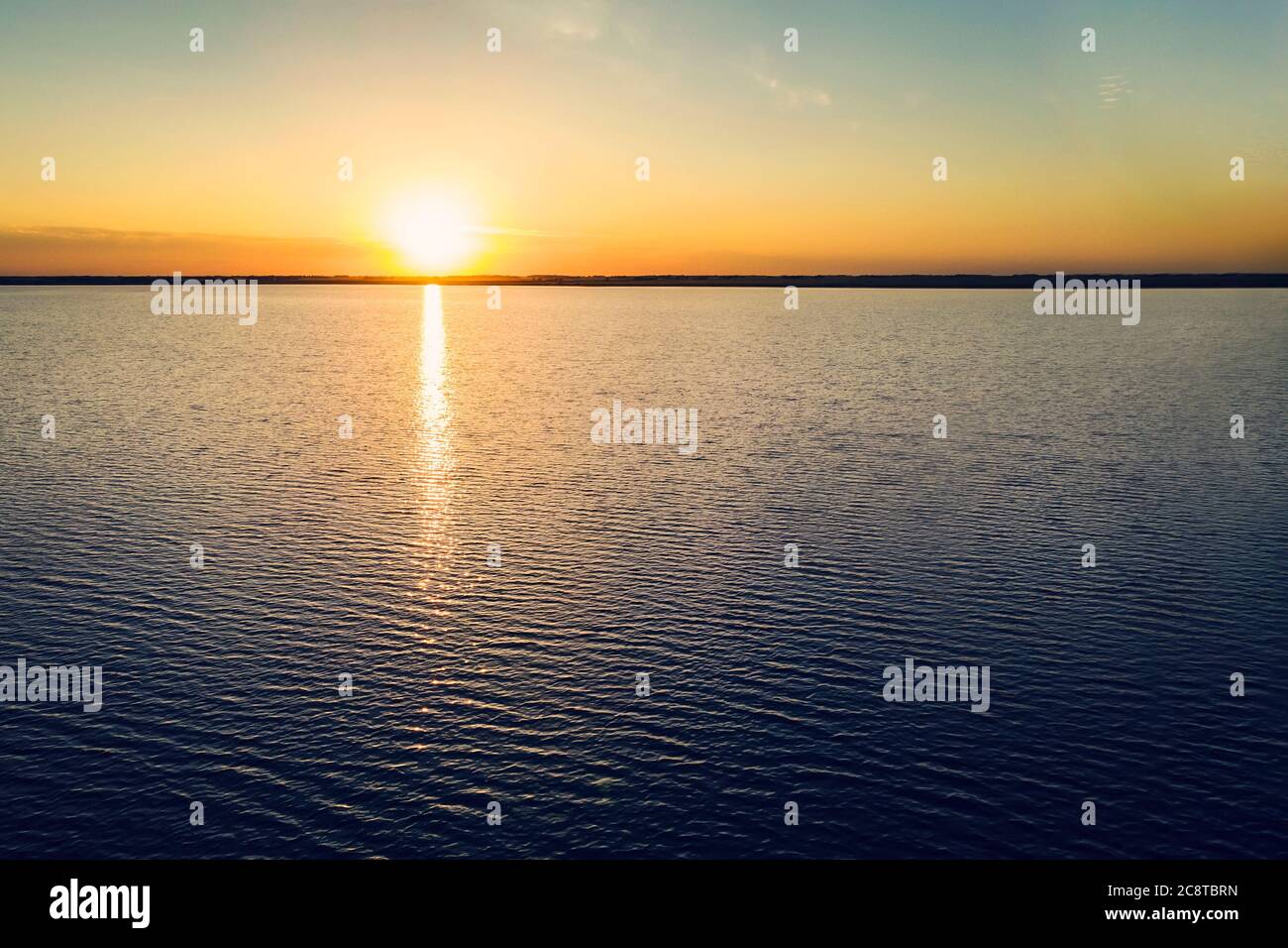 il sole giallo tramonta dietro il lago e il tramonto sulla costa del mare. Bellissimo tramonto sul lago. Bellissima alba sul lago. Proteggere l'ambiente. sun Foto Stock