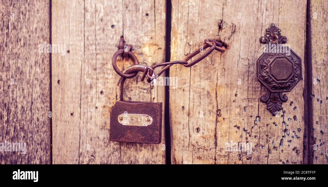 Vecchia porta in legno con maniglia, catena e serratura. Stile boho Foto Stock