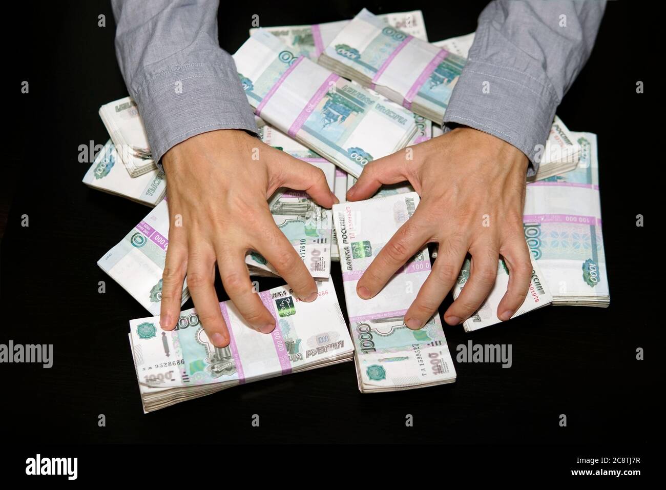 Grande pila di banconote, rubli russi, banconote 1000 rubli. Mani stanno afferrando soldi. Lussuria per soldi. Foto Stock