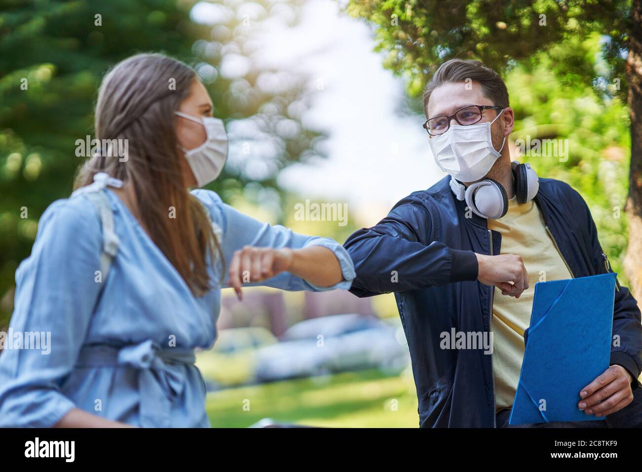 Coppia di studenti nel campus che indossano maschere a causa di pandemia di coronavirus Foto Stock