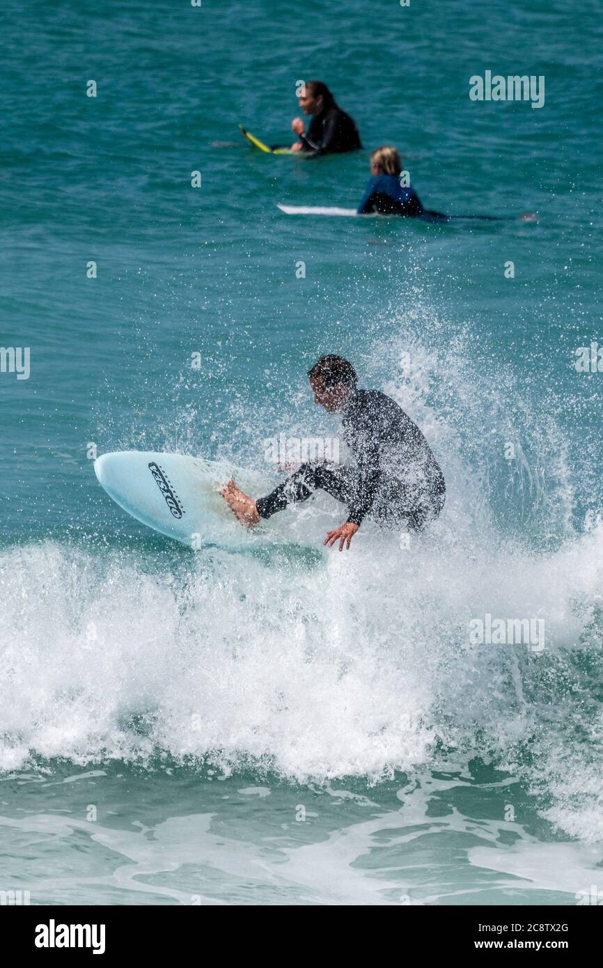 Azione spettacolare come un surfista cavalca un'onda al Fistral a Newquay in Cornovaglia. Foto Stock