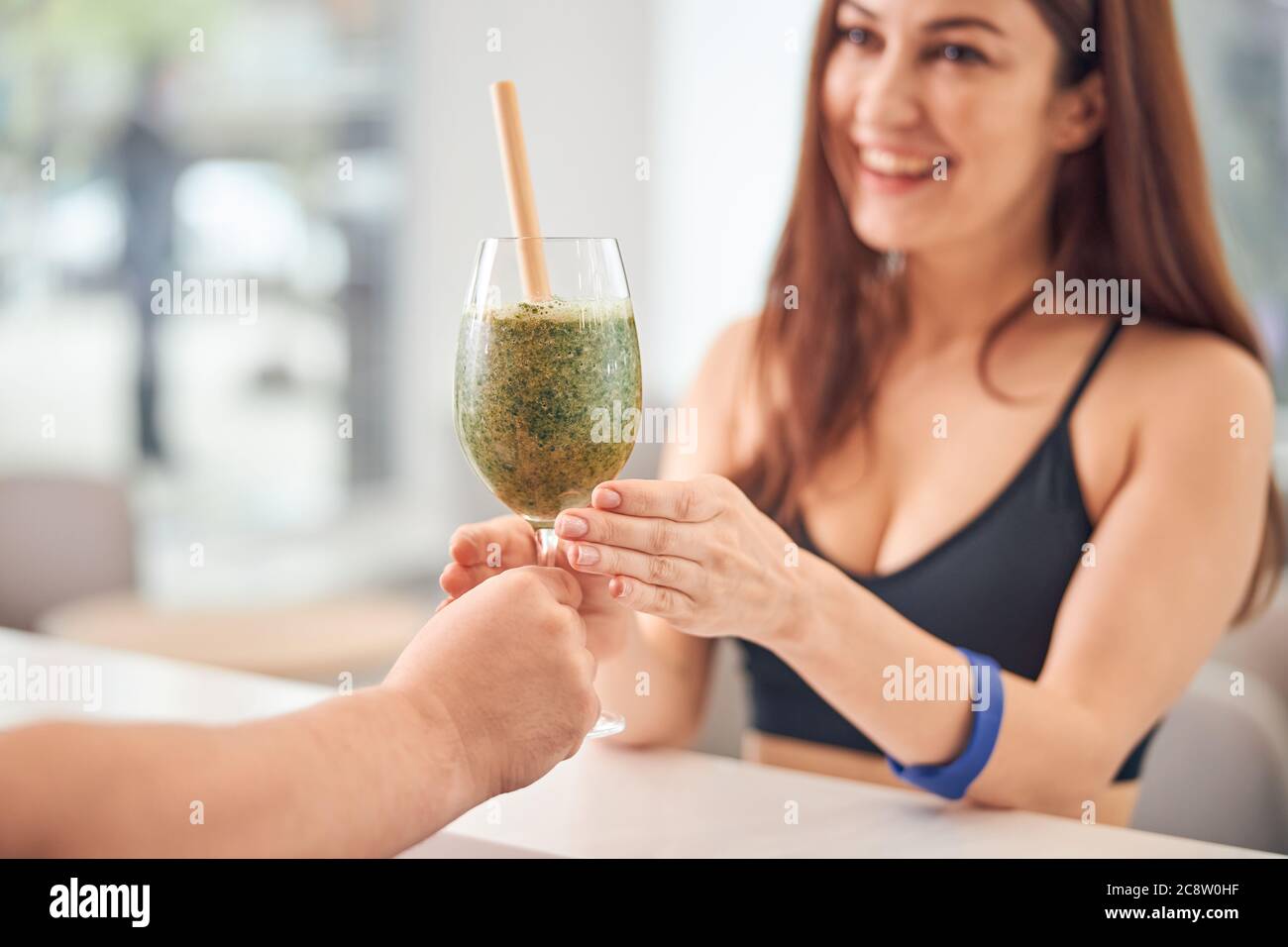 Cliente femminile che gioisce al suo frullato verde Foto Stock