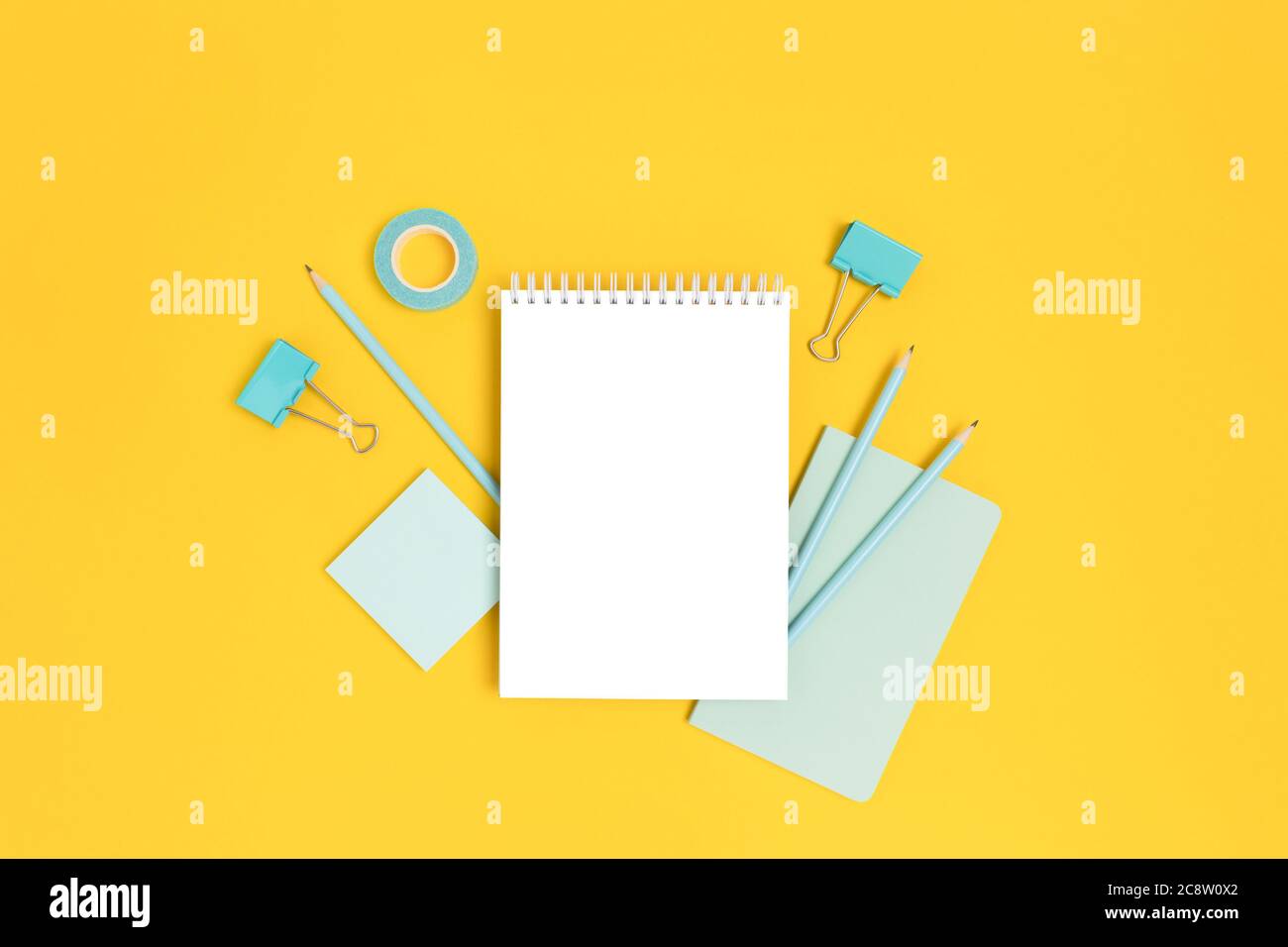 Modello Notepad con cartoleria menta su sfondo giallo brillante. Creazione di un mockup con spazio per la copia. Foto Stock
