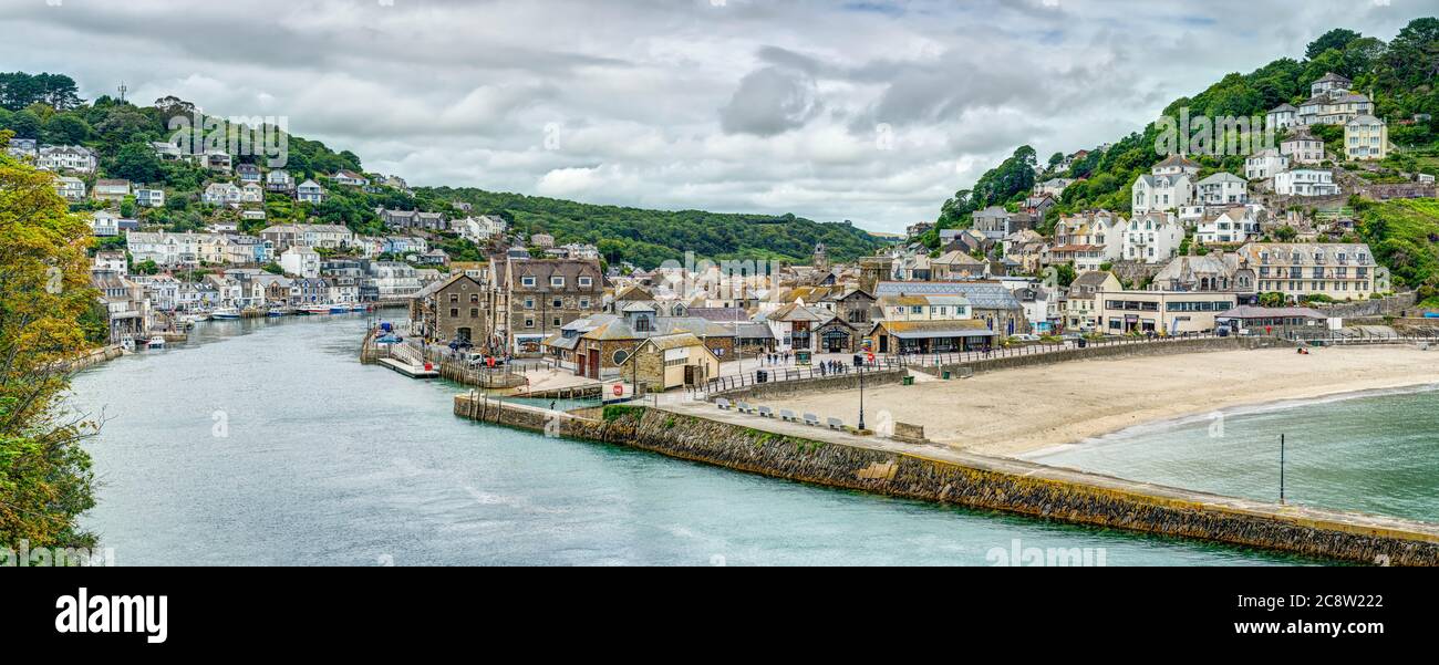 Ampia vista panoramica colorata che guarda lungo il fiume Looe verso le case di West Looe e la spiaggia sabbiosa e la graziosa cittadina di East Looe Cornwall. Foto Stock