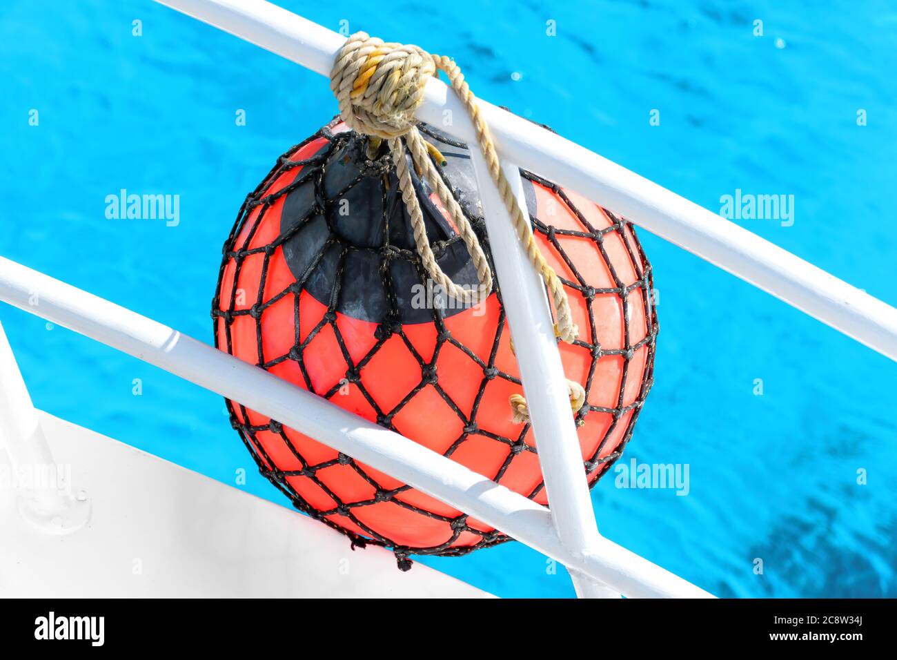 Un parafango di pera rossa per una barca in un mare cristallino turchese durante un'escursione estiva in Egitto Foto Stock