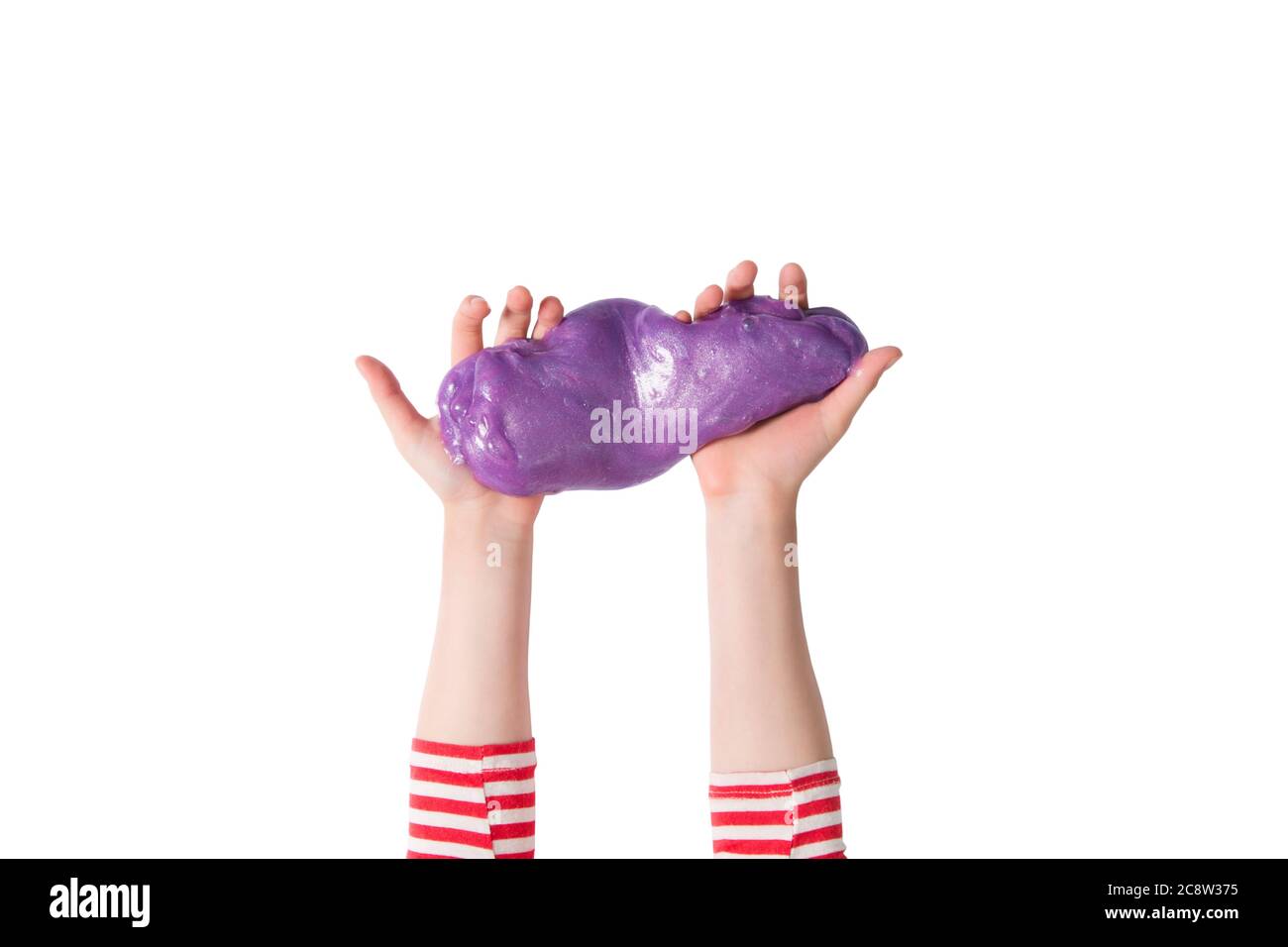 Mani adolescenti e melma viola brillante. Bambina gioca con calce isolato su bianco. Giochi educativi domestici o concetto di fai da te. Vista dall'alto, banner piatto Foto Stock