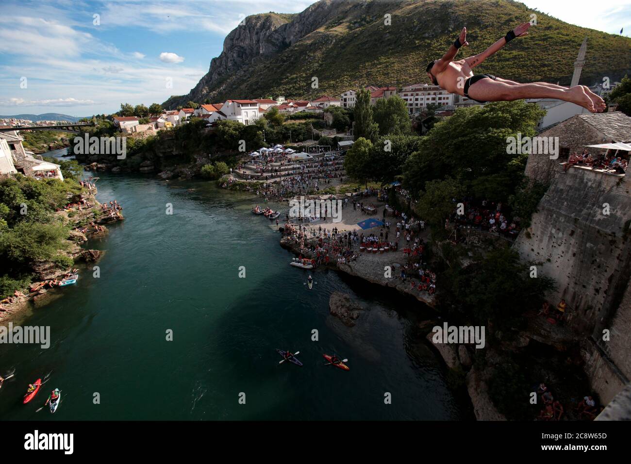 Un subacqueo salta dal Ponte Vecchio Mostar durante la 454a gara tradizionale annuale di alta immersione, a Mostar, Bosnia, 140 chilometri (87 miglia) sou Foto Stock