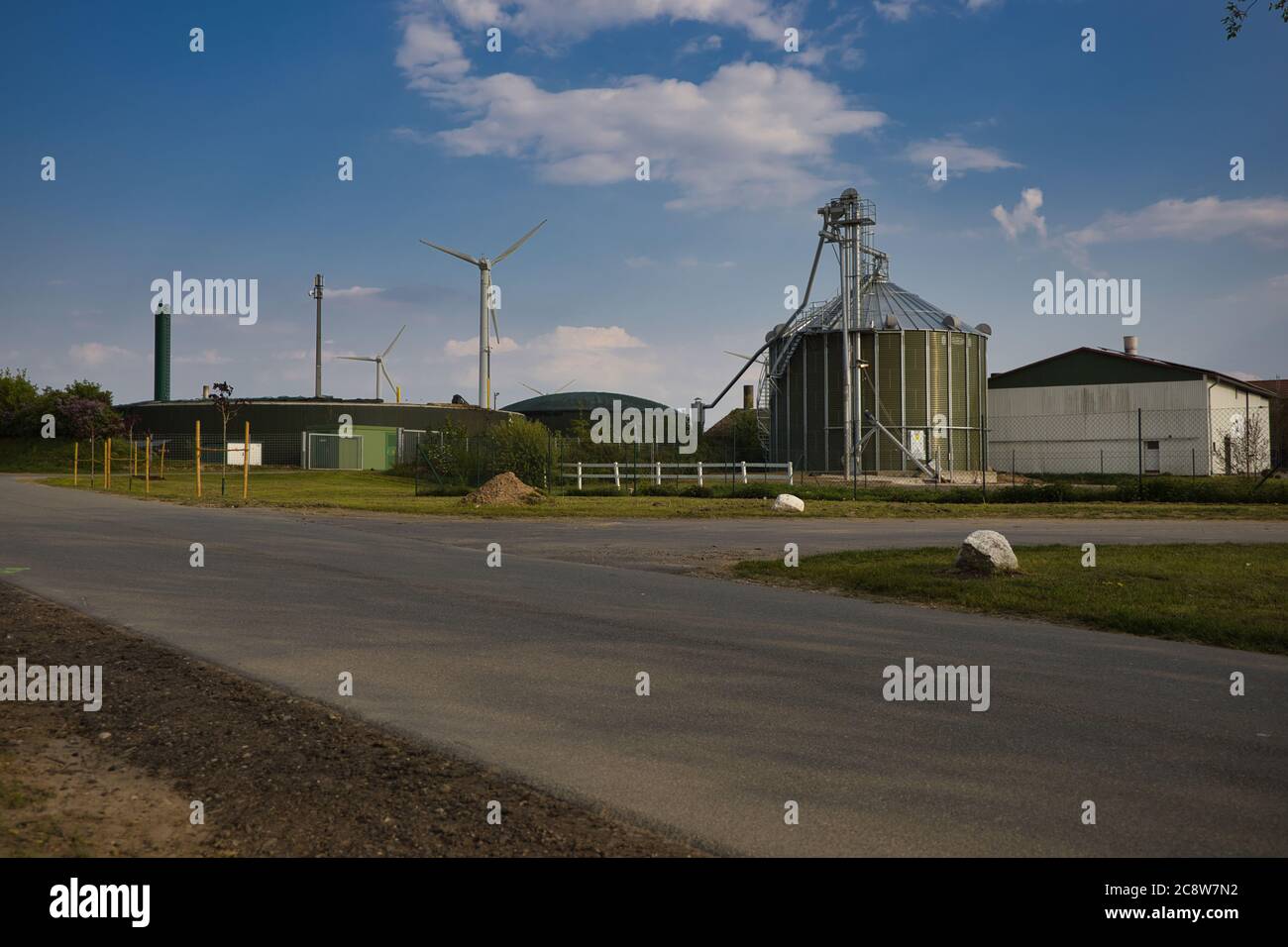 TRENT, GERMANIA - 09 maggio 2020: Trent, Schleswig-Holstein, Germania, 9 maggio. 2020 impianto di biogas in background turbine eoliche, cielo blu e nuvole bianche Foto Stock