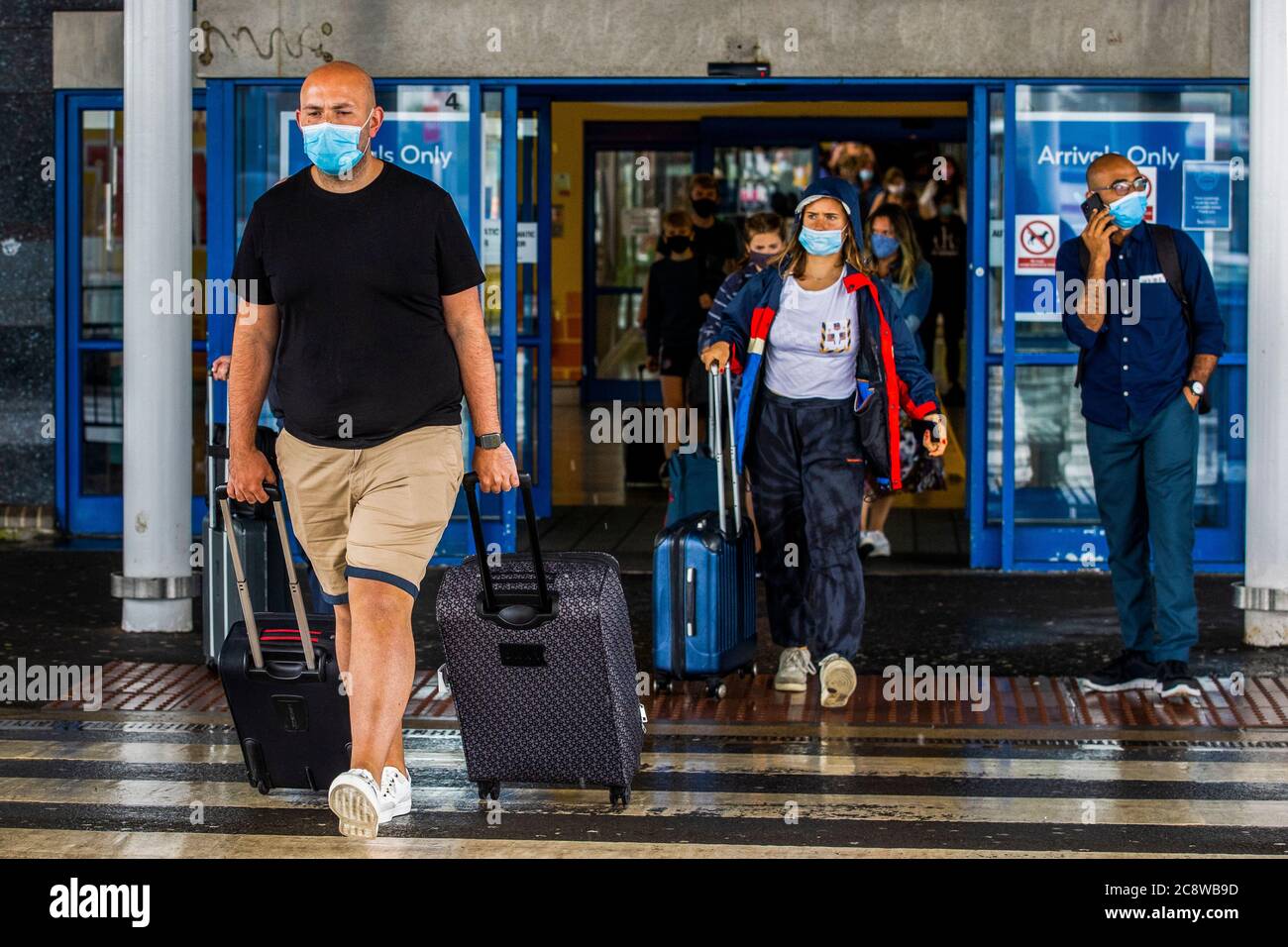 Passeggeri che lasciano l'aeroporto internazionale di Belfast. L'esecutivo dell'Irlanda del Nord è destinato a riunirsi più tardi per discutere una decisione di introdurre la quarantena per coloro che arrivano nella regione dalla Spagna. Foto Stock