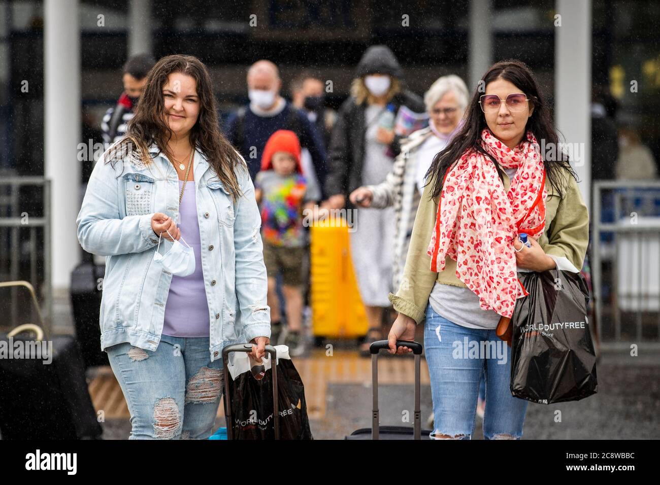 Aleksanda Sabalina (a sinistra) e Edith Mikutenaite che vivono nell'abbazia di Newtownabbey hanno mostrato di lasciare l'aeroporto internazionale di Belfast dopo essere arrivati sul volo EJU6672 di Easyjet alle 10:00 da Barcellona, Spagna. L'esecutivo dell'Irlanda del Nord è destinato a riunirsi più tardi per discutere una decisione di introdurre la quarantena per coloro che arrivano nella regione dalla Spagna. Foto Stock