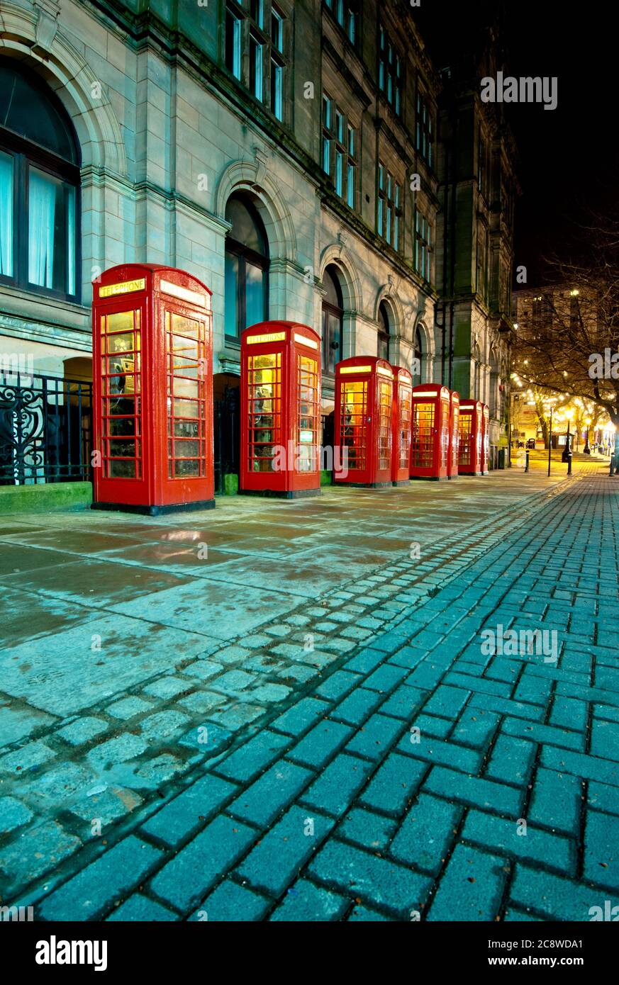 Fila di tradizionali scatole telefoniche rosse a Preston, Lancashire, Regno Unito. Foto Stock