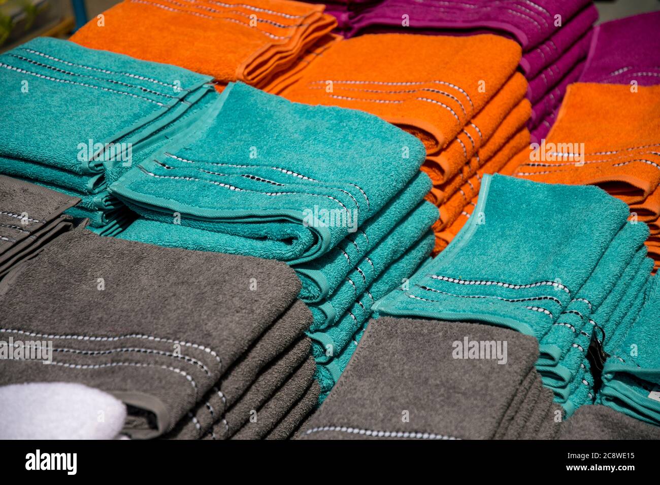 asciugamani di colore diverso su pila per la vendita Foto Stock