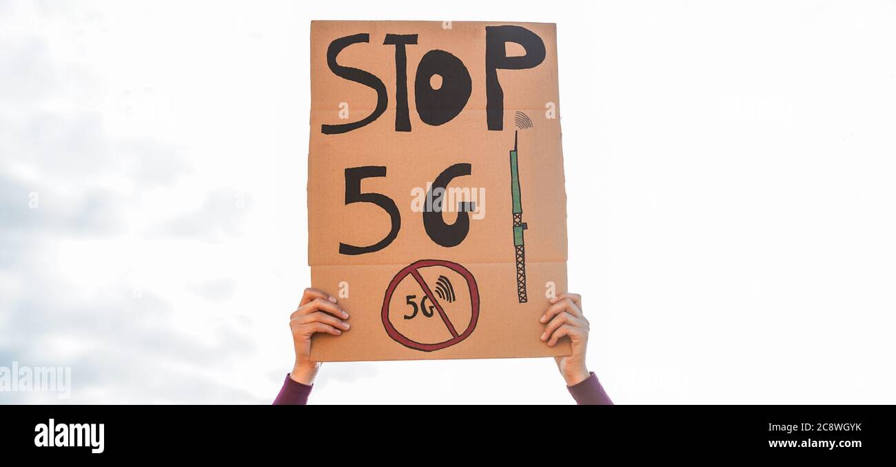 Giovane donna protesta contro 5g e torri cellulari - l'inquinamento elettromagnetico e l'Internet delle cose concetto - Focus sulla bandiera Foto Stock