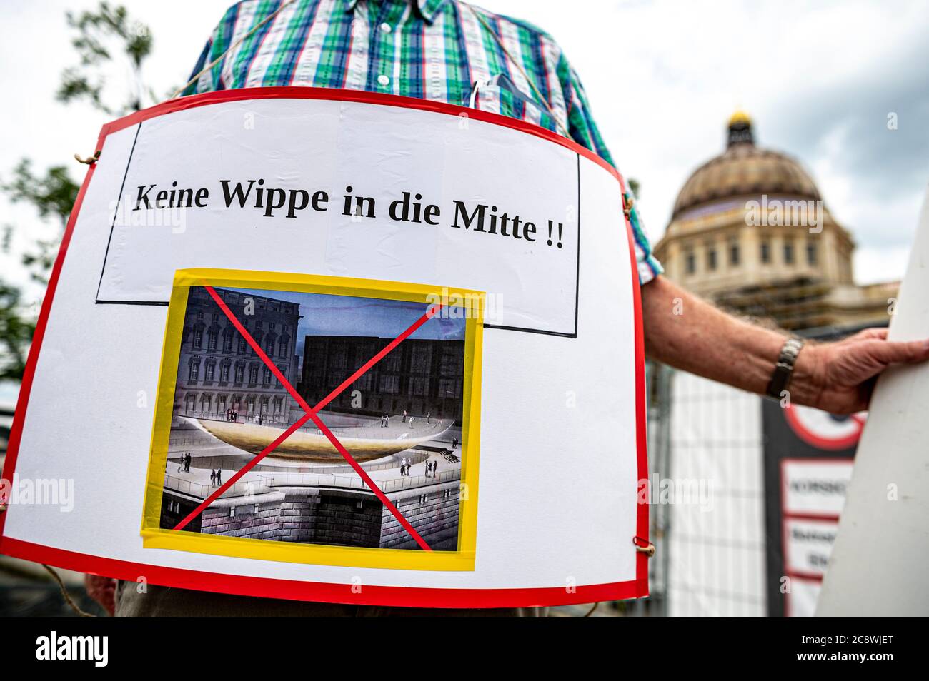 Berlino, Germania. 27 luglio 2020. Un cittadino, che ha seguito la protesta dell'Associazione del Centro storico di Berlino, indossa un cartello intorno al collo con l'iscrizione "No seesaw in Mitte". La base storica dell'ex monumento nazionale Kaiser Wilhelm deve essere parzialmente distrutta per la costruzione del monumento unificato. Credit: Fabian Sommer/dpa/Alamy Live News Foto Stock