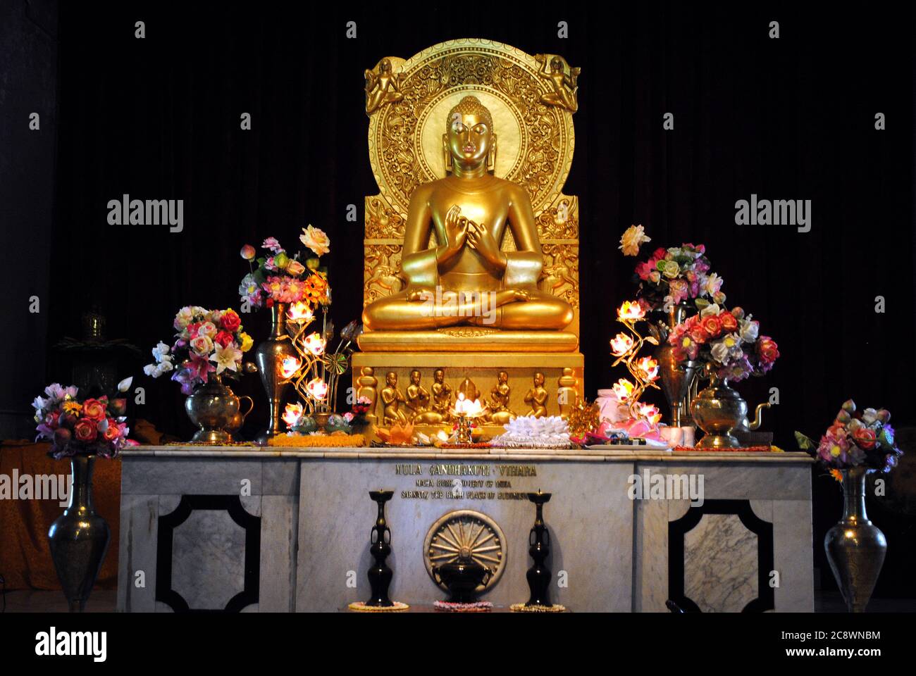 Seduto Golden Buddha statua in un tempio buddista a Mulagandhakuti vihara, Sarnath, Varanasi. Foto Stock