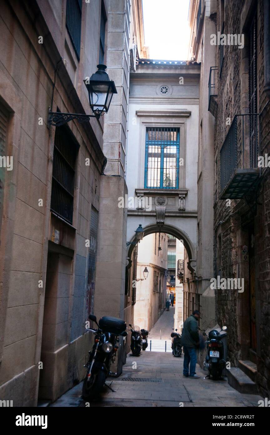 Un passaggio ad arco su una stretta strada medievale nel quartiere gotico di Barcellona, in Spagna. Foto Stock