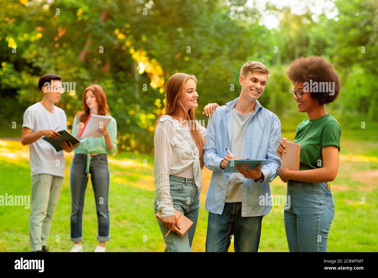 Interruzione tra classi. Gruppo di studenti universitari multiculturali che si trovano all'aperto Foto Stock