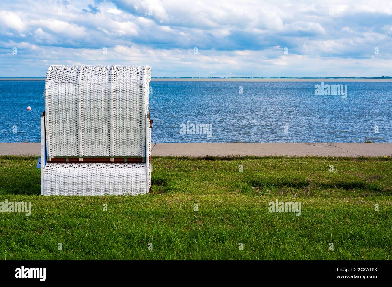 Una sedia da spiaggia in un prato vicino al mare. La vicina sedia da spiaggia è stata rimossa come parte della prevenzione Covid-19. Foto Stock