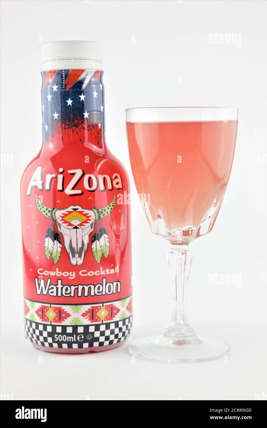 Bicchiere di cocktail al cocomero con bordo zuccherato e una bottiglia di cocktail Arizona cowboy isolato su sfondo bianco in formato verticale Foto Stock