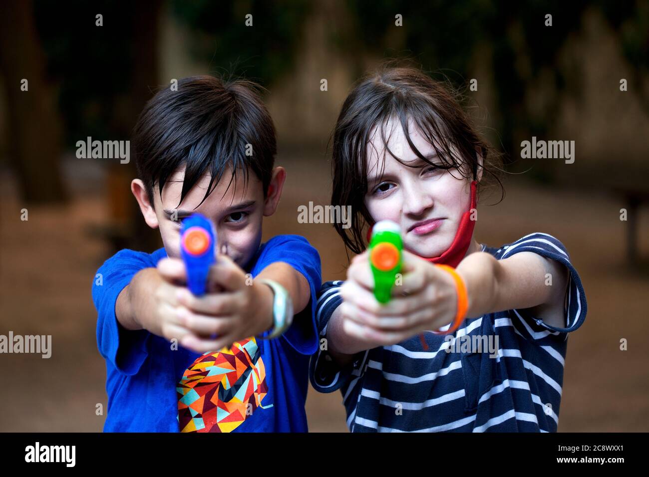 Due ragazzi di 11 anni che puntano le pistole ad acqua. Foto Stock