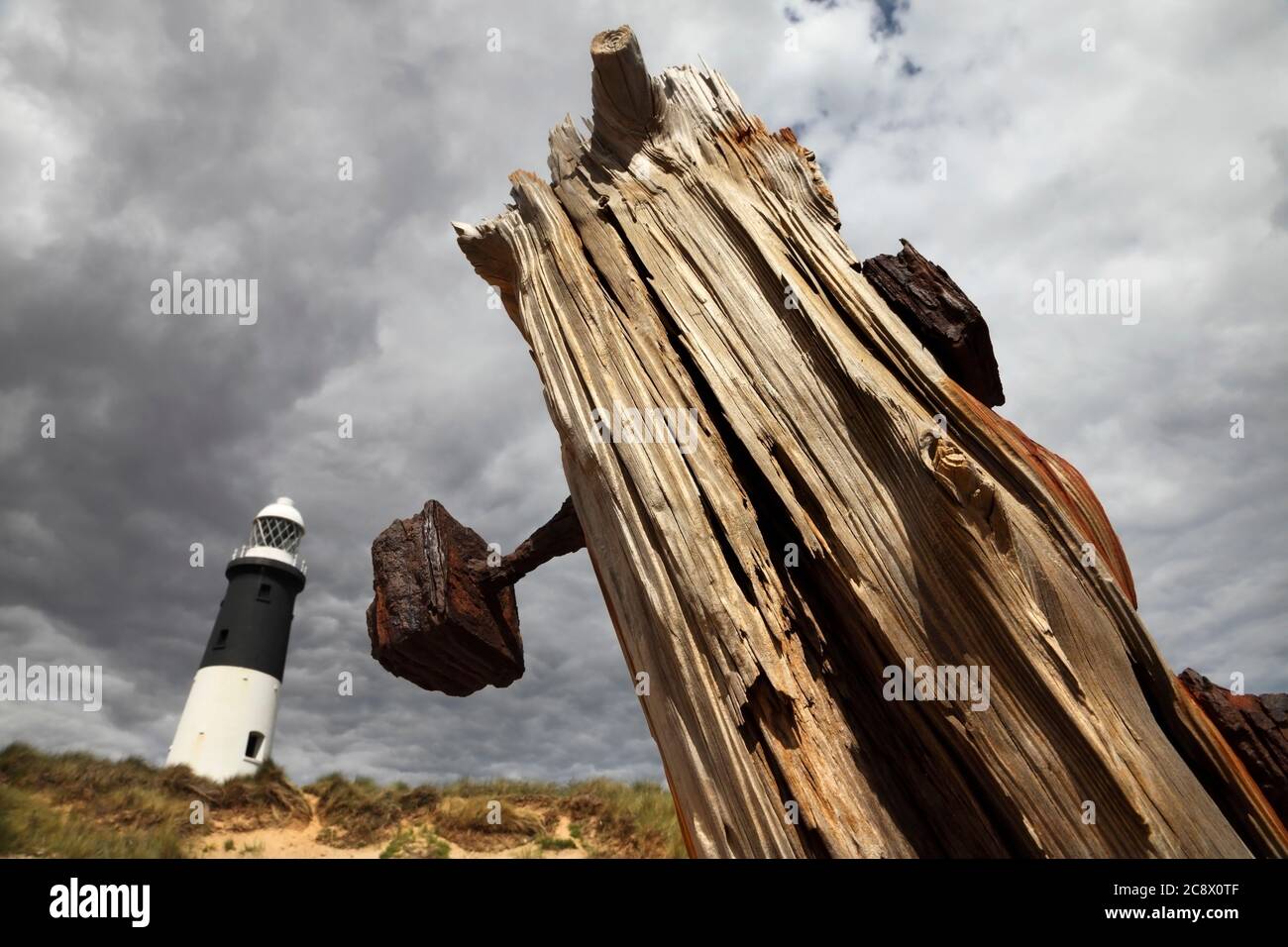 Difesa del mare di legno e faro di ritorno a Spurn Point, vicino a Kilnsea, East Yorkshire, Regno Unito. Foto Stock