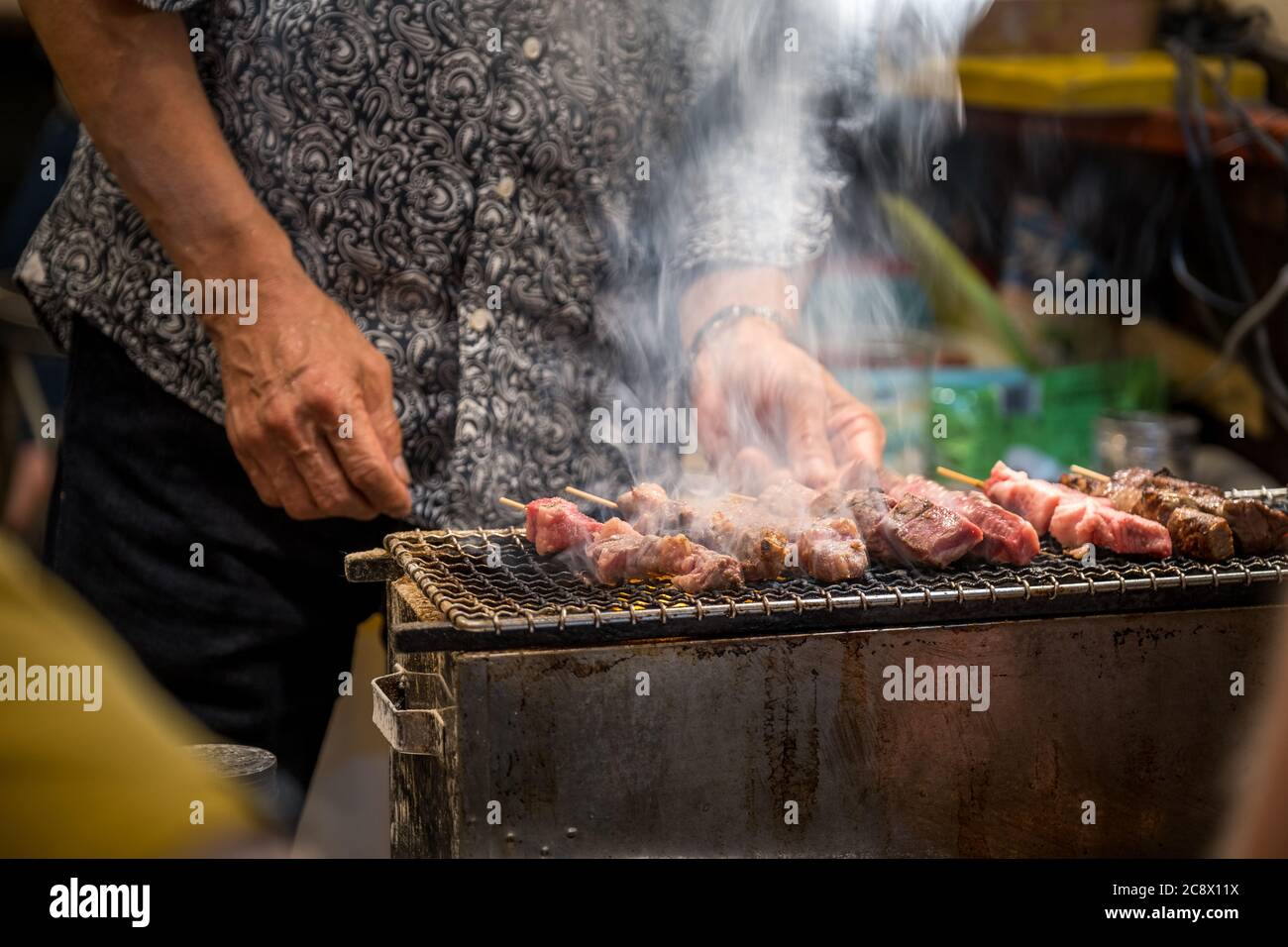 primo piano di un uomo che fa barbecue Foto Stock