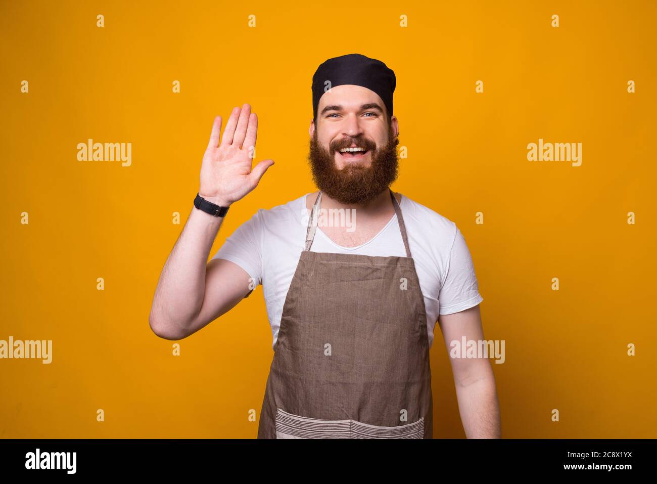 Foto di felice cuoco alato che saluta tutti. Foto Stock