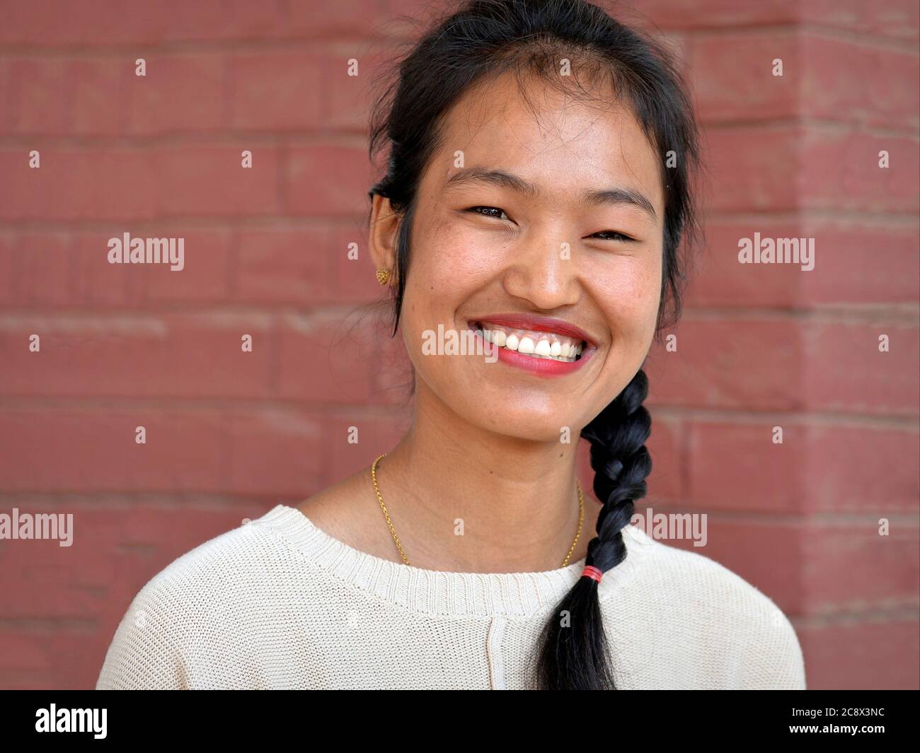 Giovane donna birmana con sorrisi di passera per la macchina fotografica. Foto Stock