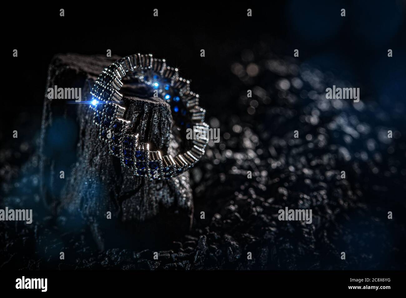 Anello dei gioielli con pietre blu su sfondo scuro Foto Stock