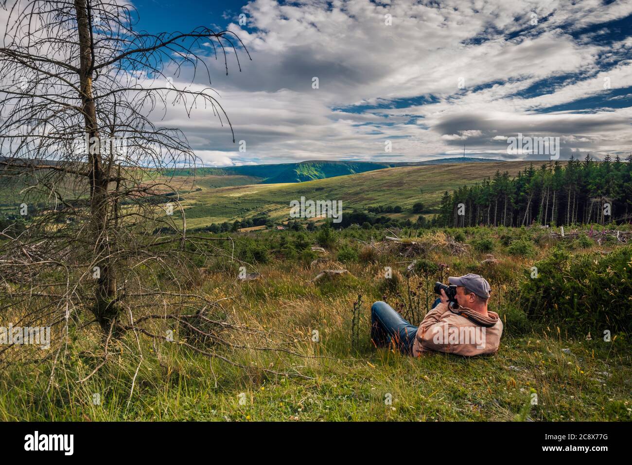 Fotografo di paesaggi. Uomo con macchina fotografica che fa le immagini delle montagne di Wicklow. Irlanda. Foto Stock