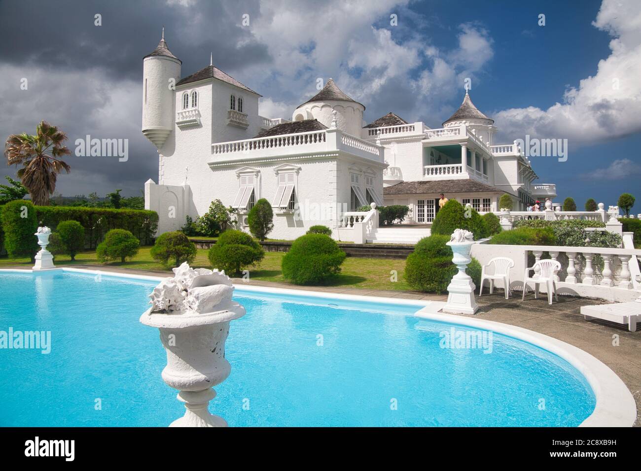 Una casa dipinta di bianco molto ornato e piscina in Giamaica, i Caraibi Foto Stock