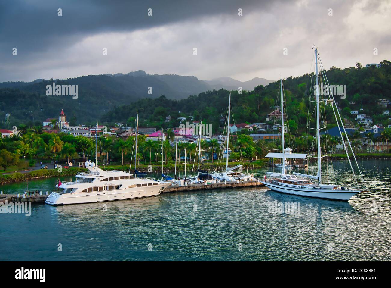Porto scena sulla costa della Giamaica, i Caraibi, con yacht ormeggiati e le colline boscose dell'isola oltre Foto Stock