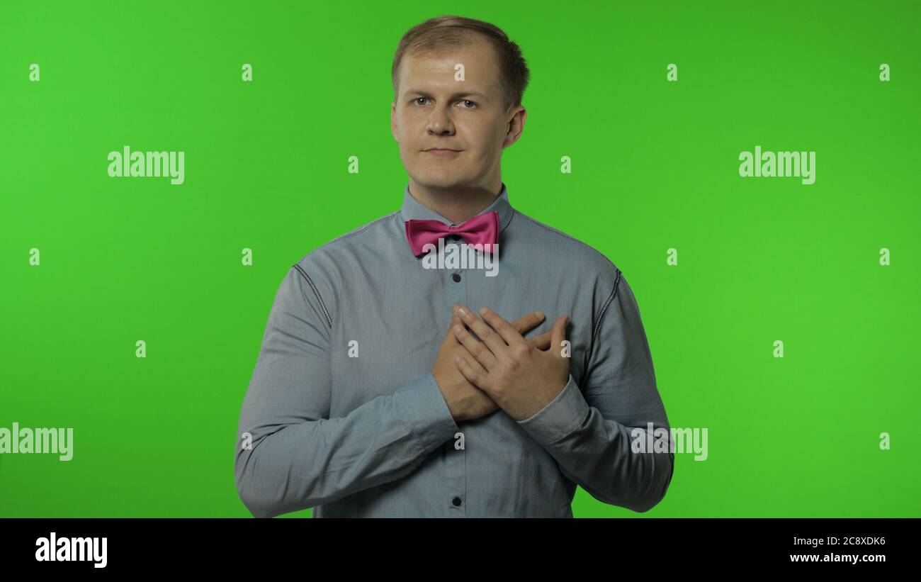 Bell'uomo dal cuore aperto che dà dal cuore, gesturing prenderlo gratuitamente, cercando gentilmente, condividendo la cura dell'amore, concetto di generosità. Ritratto di ragazzo che posa isolato su sfondo chiave chroma Foto Stock