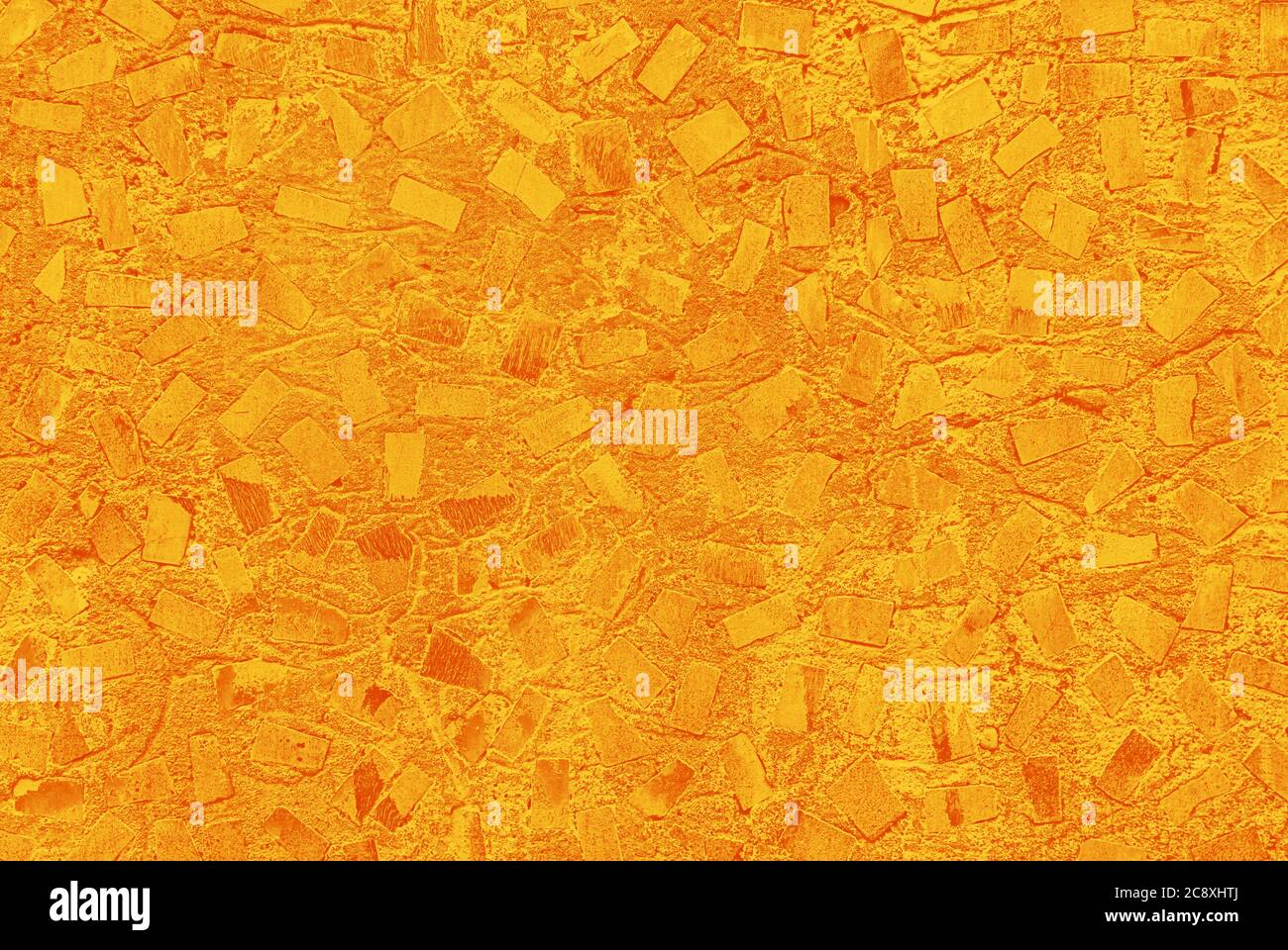 struttura astratta giallo-arancio di parete in cemento verniciata con motivo a mosaico casuale Foto Stock