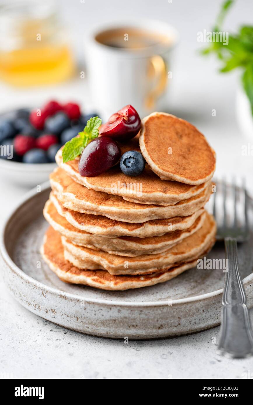 Frittelle di avena vegana con frutti di bosco su piatto. Frittelle senza glutine Foto Stock
